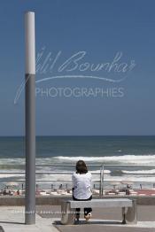 Image du Maroc Professionnelle de  Une femme assise sur un banc public contemplant l’étendue de la mer qui est dépourvue de lieu caché, au bord de la fameuse corniche de Aïn Diab à Casablanca, Lundi  7 Juillet 2009. Seule et détachée de tout, bercé par le perpétuel mouvement des vagues. Face à cette nature océanique, il est indéniable que nous sommes envahis par une sensation de bien être, de repos et de relaxation. (Photo / Abdeljalil Bounhar)
